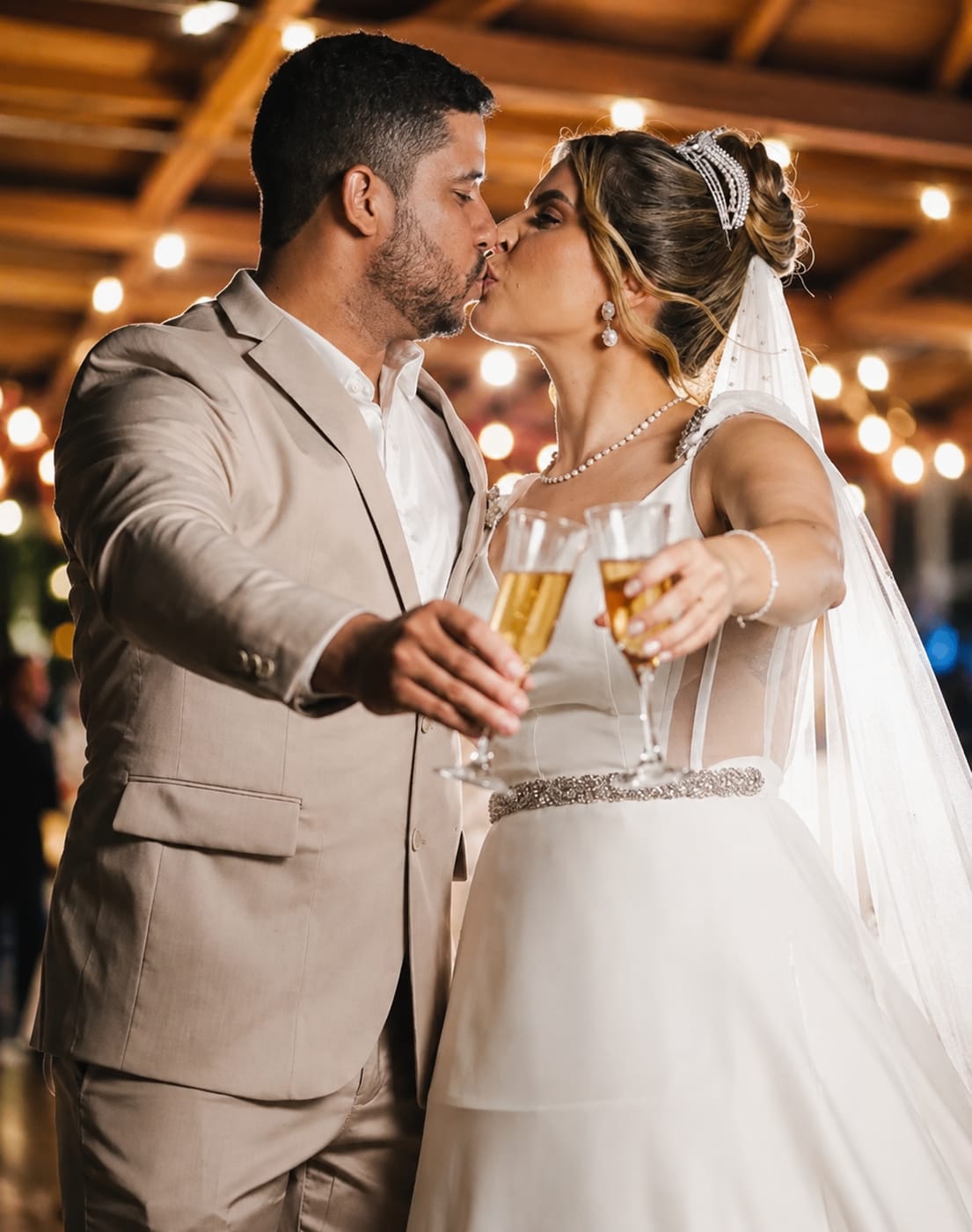 Noivos brindando com taças durante a recepção do casamento